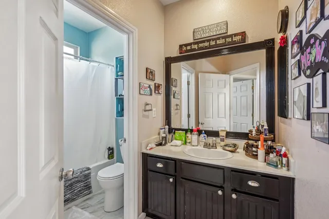 a bathroom with a double vanity sink mirror and toilet