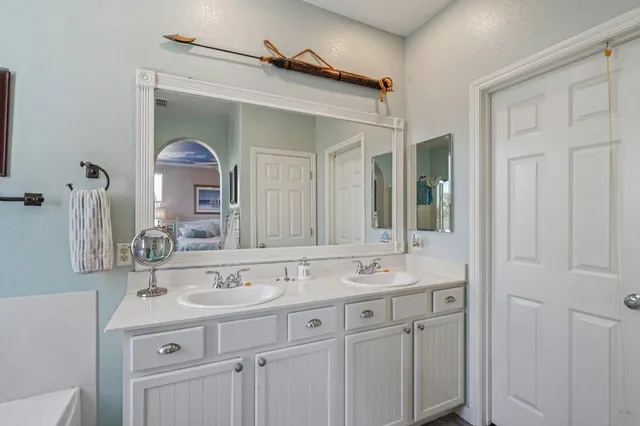 a bathroom with a double vanity sink mirror and shower