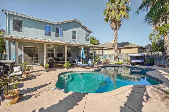 a front view of a house with swimming pool having outdoor seating