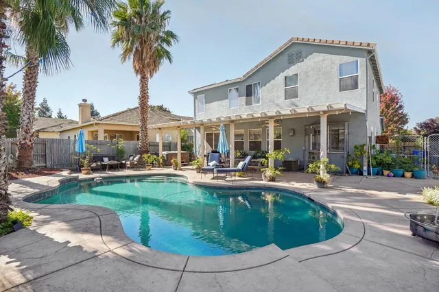 a view of swimming pool with outdoor seating and plants