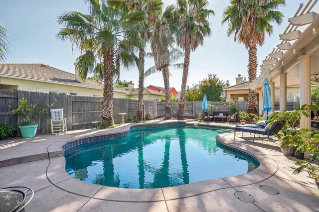 a swimming pool with outdoor seating and yard