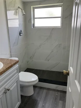 a bathroom with a toilet and a shower