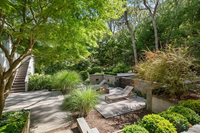 a view of backyard with plants and outdoor seating
