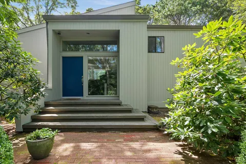 a front view of a house with plants