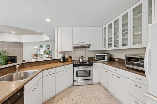 a kitchen with stainless steel appliances granite countertop a sink and cabinets with wooden floor