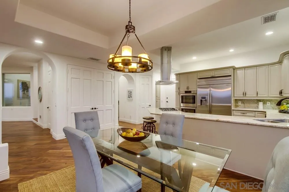 7411 Hillside Drive La Jolla, CA 92037 - Photo 12 of 25 a kitchen with stainless steel appliances kitchen island granite countertop a table and chairs in it