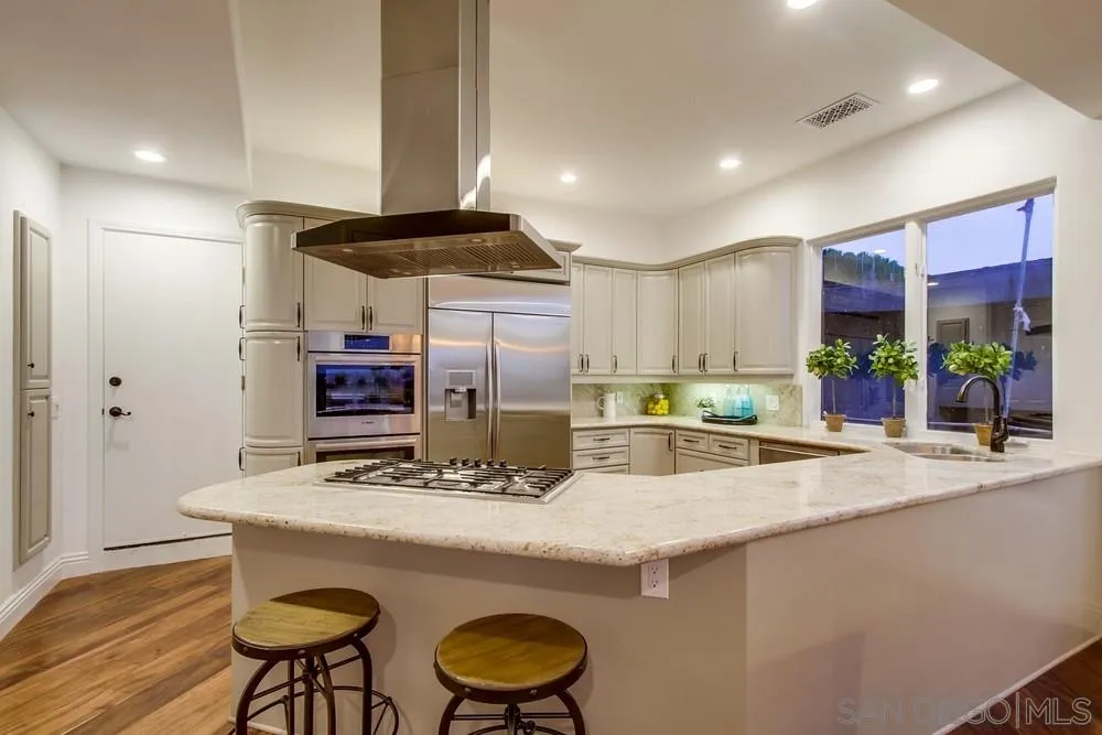 7411 Hillside Drive La Jolla, CA 92037 - Photo 13 of 25 a kitchen with stainless steel appliances granite countertop a sink and a refrigerator