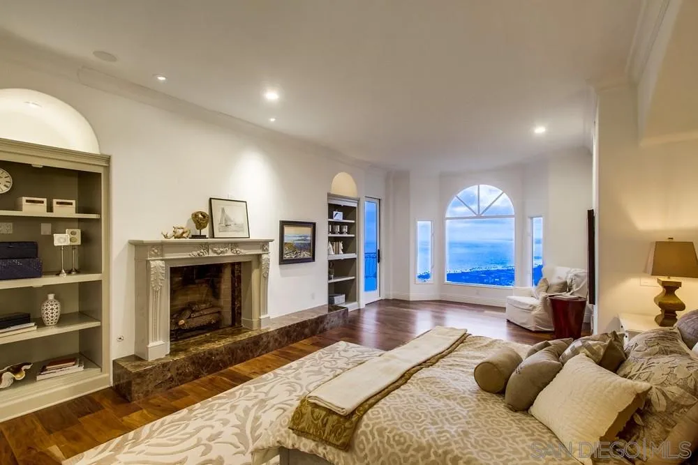 7411 Hillside Drive La Jolla, CA 92037 - Photo 15 of 25 a spacious bedroom with a bed and a fireplace