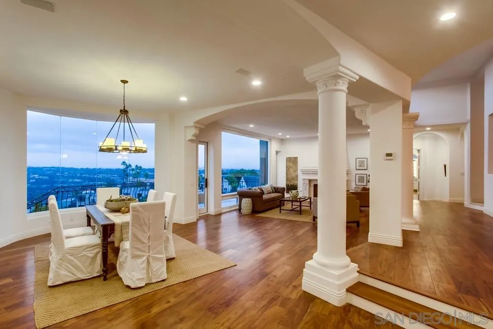 7411 Hillside Drive La Jolla, CA 92037 - Photo 3 of 25 a dining room with wooden floor a chandelier a glass table and chairs