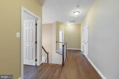 a large bedroom with a bed and wooden floor