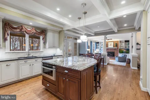 a kitchen with stainless steel appliances granite countertop a kitchen island a table and chairs in it