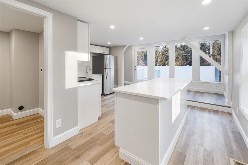a large white kitchen with a sink and refrigerator
