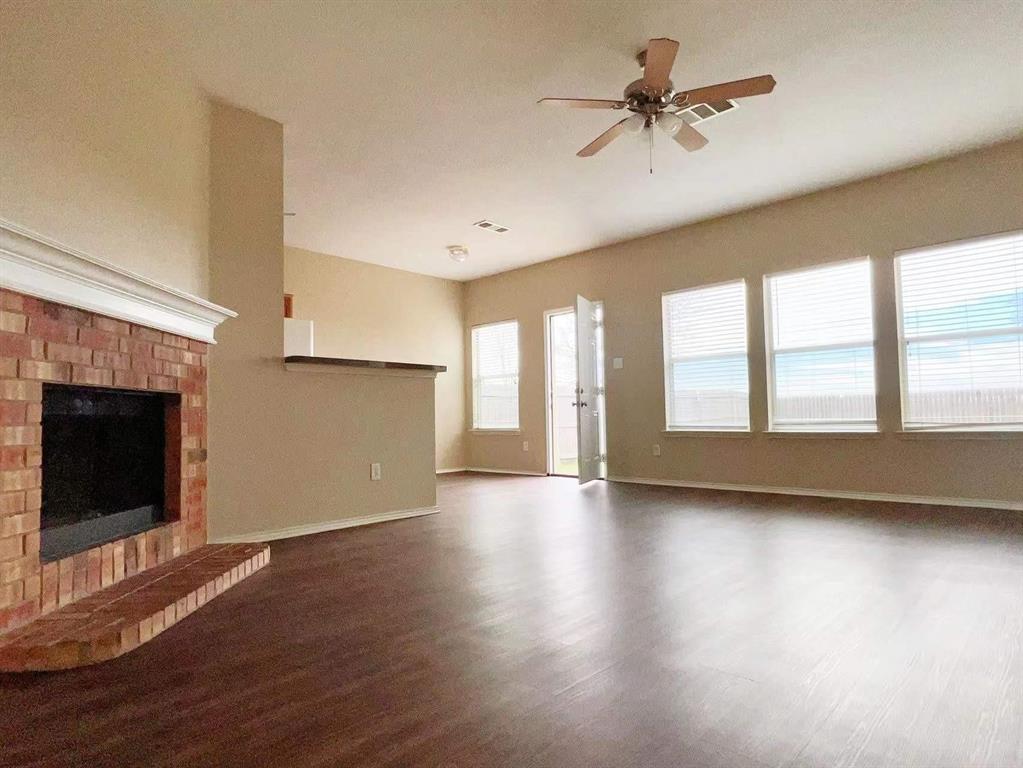 10416 Phantom Hill Road Fort Worth, TX 76140 - Photo 2 of 13 a view of an empty room with a window and wooden floor