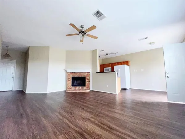 a view of empty room with wooden floor and fireplace