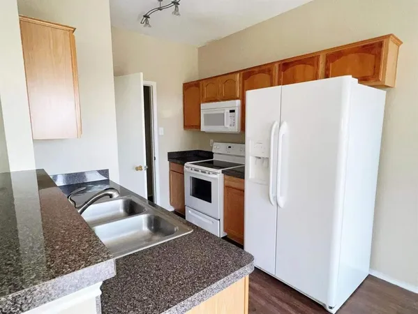 a kitchen with stainless steel appliances granite countertop a refrigerator sink and stove