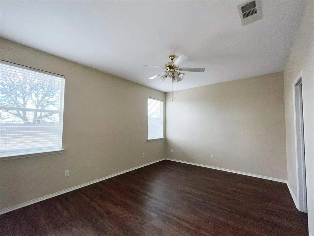 10416 Phantom Hill Road Fort Worth, TX 76140 - Photo 6 of 13 a view of an empty room with a window and wooden floor
