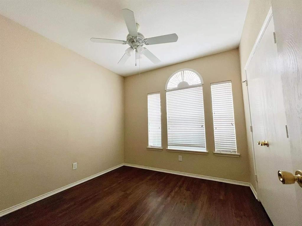 10416 Phantom Hill Road Fort Worth, TX 76140 - Photo 10 of 13 an empty room with wooden floor chandelier fan and windows