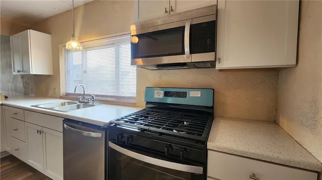 a kitchen with stainless steel appliances a stove and a microwave