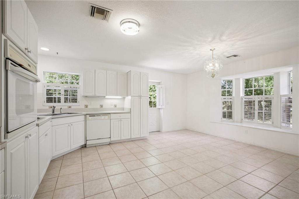 5348 Cypress Lane Naples, FL 34113 - Photo 8 of 28 a large white kitchen with cabinets