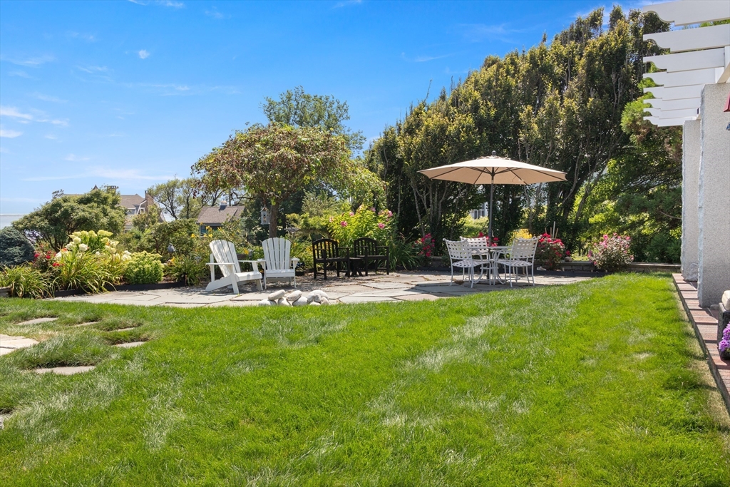 13 Phillips Avenue Rockport, MA 01966 - Photo 35 of 39 a backyard of a house with table and chairs under an umbrella