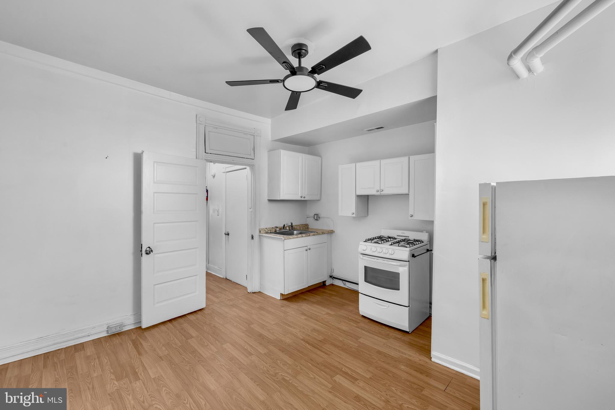 2920 Parkwood Avenue, Unit 3 Baltimore, MD 21217 - Photo 6 of 12 a kitchen with white cabinets and stainless steel appliances