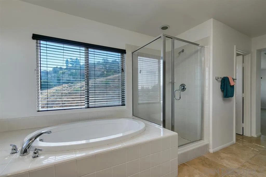 10472 Celestial Waters Drive Spring Valley, CA 91977 - Photo 17 of 24 a bathroom with a tub and a shower