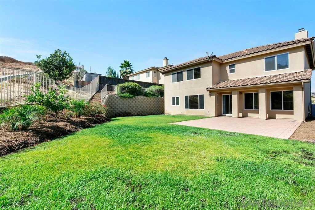 10472 Celestial Waters Drive Spring Valley, CA 91977 - Photo 21 of 24 a front view of a house with a yard and potted plants