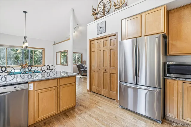 a kitchen with stainless steel appliances granite countertop a refrigerator a sink and a stove