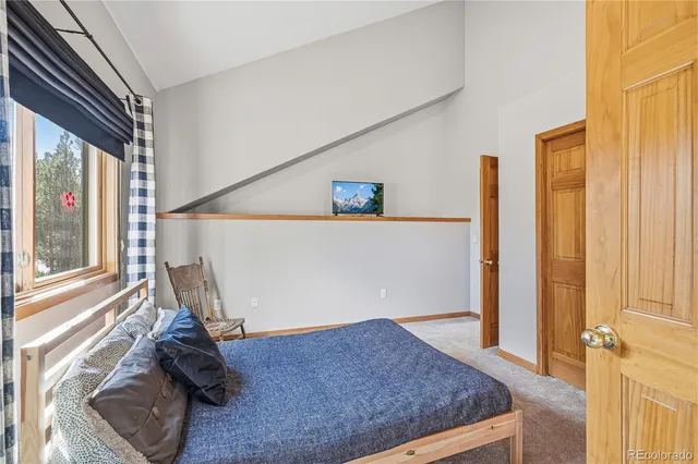 a bed sitting in a bedroom next to a window