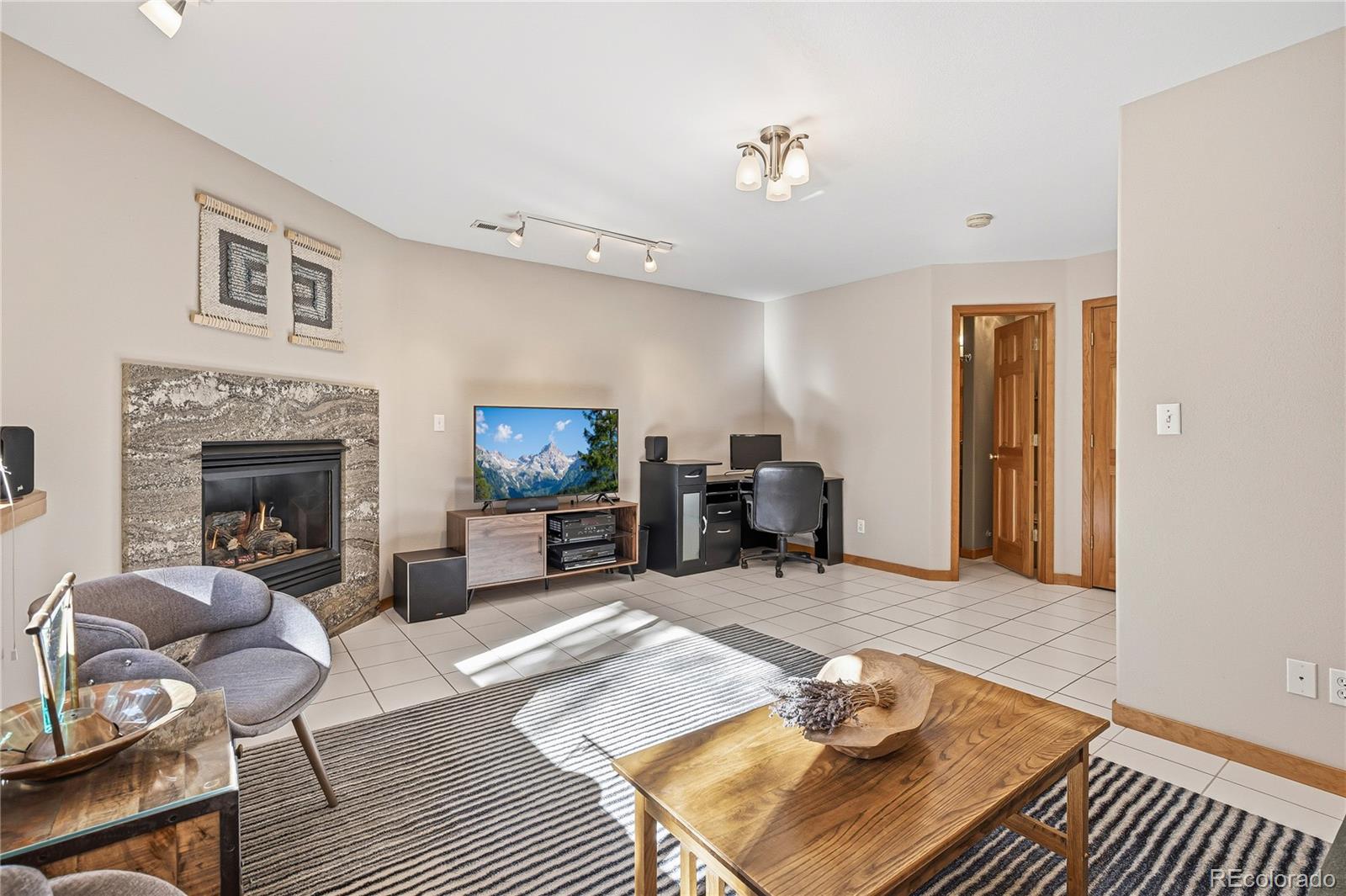 9274 Sandy Lane Conifer, CO 80433 - Photo 38 of 48 a living room with furniture a fireplace and a flat screen tv
