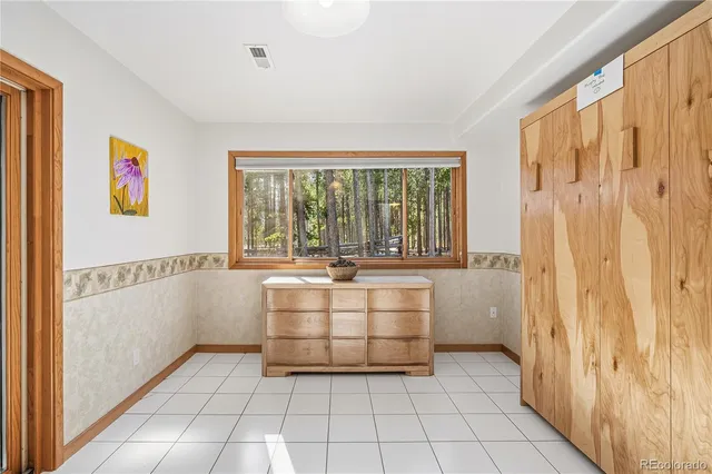 a view of a livingroom with wooden floor and a refrigerator