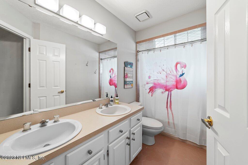10079 Pebble Ridge Drive North Jacksonville, FL 32220 - Photo 15 of 32 a bathroom with a granite countertop sink vanity mirror and toilet