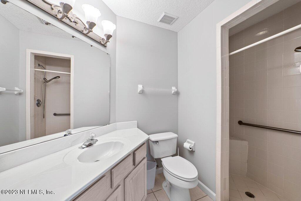 10079 Pebble Ridge Drive North Jacksonville, FL 32220 - Photo 17 of 32 a bathroom with a sink a toilet a mirror and shower