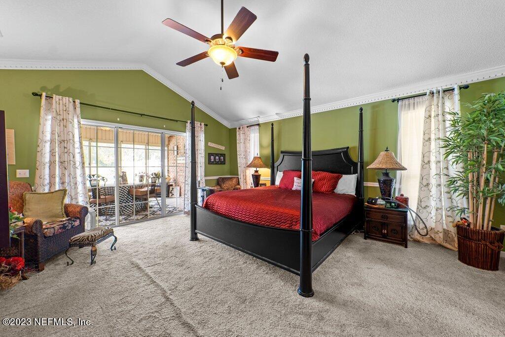 10079 Pebble Ridge Drive North Jacksonville, FL 32220 - Photo 19 of 32 a bedroom with a large bed and a chandelier fan