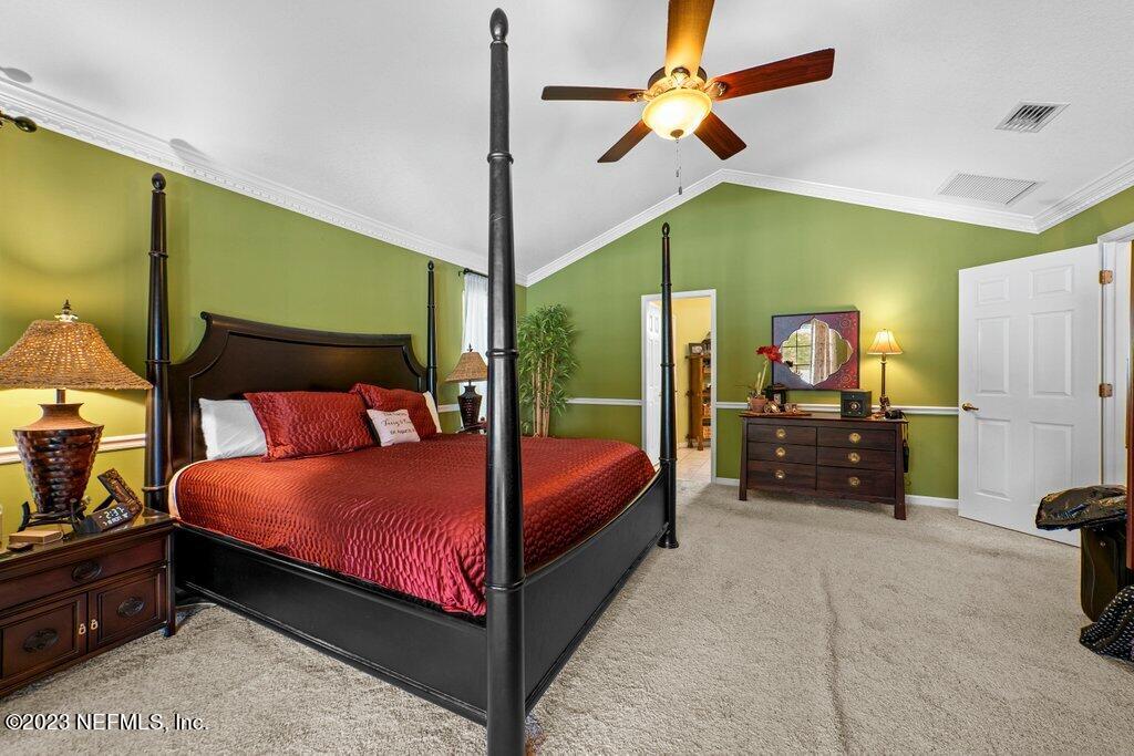 10079 Pebble Ridge Drive North Jacksonville, FL 32220 - Photo 20 of 32 a bedroom with a bed a table and flat screen tv