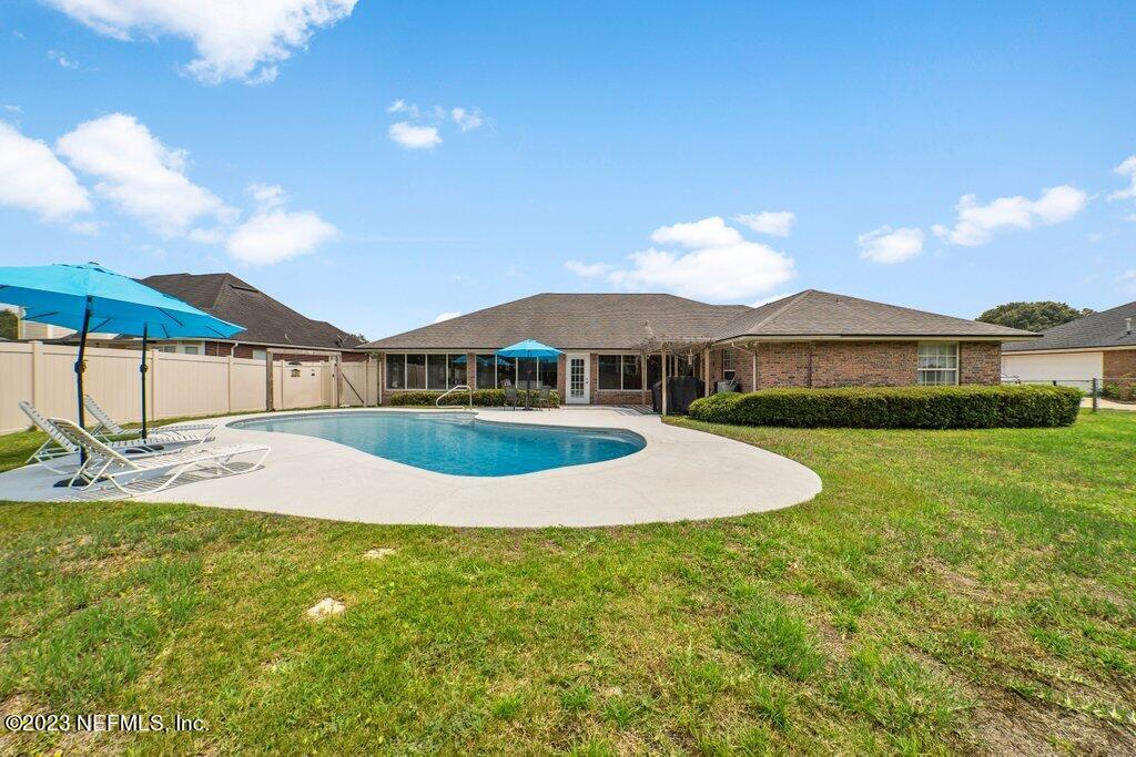 10079 Pebble Ridge Drive North Jacksonville, FL 32220 - Photo 29 of 32 a view of a house with swimming pool and yard