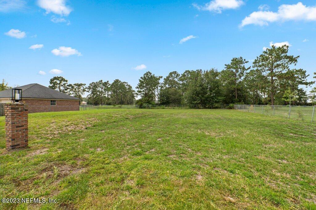 10079 Pebble Ridge Drive North Jacksonville, FL 32220 - Photo 30 of 32 a view of a grassy field with trees in the background
