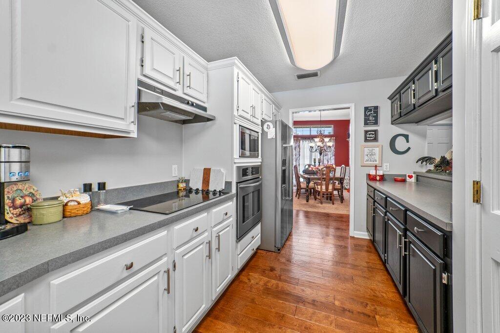 10079 Pebble Ridge Drive North Jacksonville, FL 32220 - Photo 10 of 32 a kitchen with stainless steel appliances granite countertop a lot of cabinets