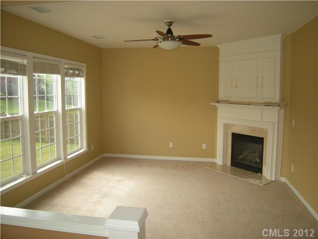 2401 Coltsgate Road, Unit 80 Waxhaw, NC 28173 - Photo 3 of 16 a view of an empty room with a fireplace and a window