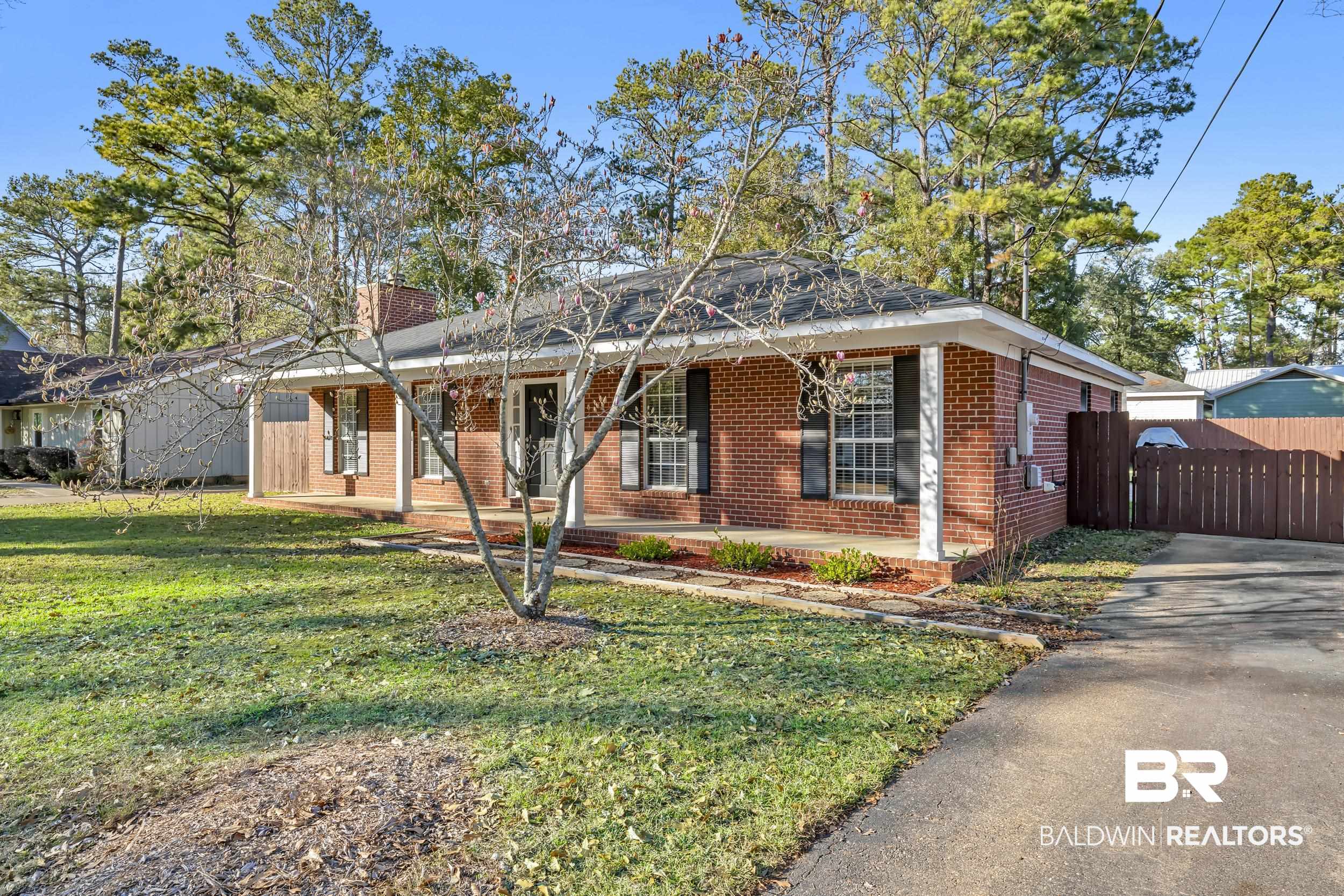 125 Dunbar Loop Daphne, AL 36526 - Photo 2 of 17 View of front of property featuring a porch, brick siding, a front yard, and a chimney