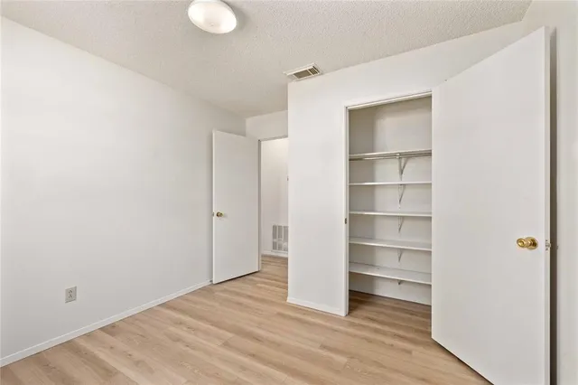 a view of a room with wooden floor and closet