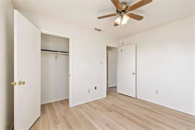 a view of an empty room with a ceiling fan