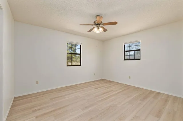 a view of a big room with wooden floor and windows