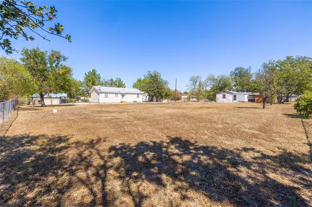 a view of big yard with large trees