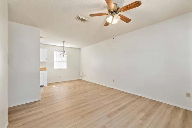 an empty room with windows and fan