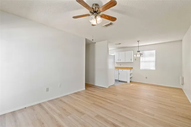 a view of a kitchen with wooden floor and a ceiling fan