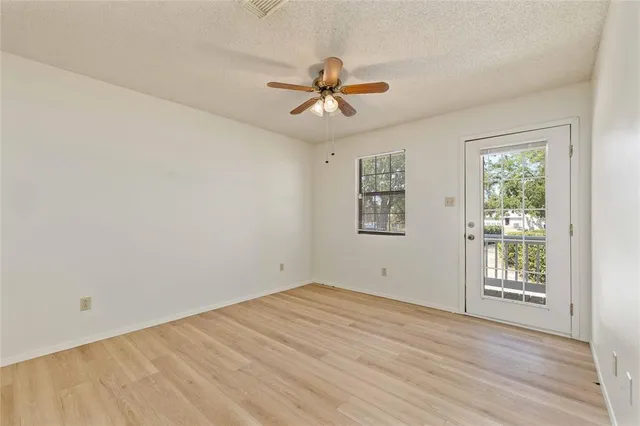 an empty room with windows and fan