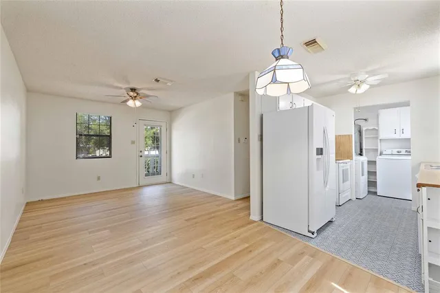 a view of a livingroom with wooden floor and a chandelier