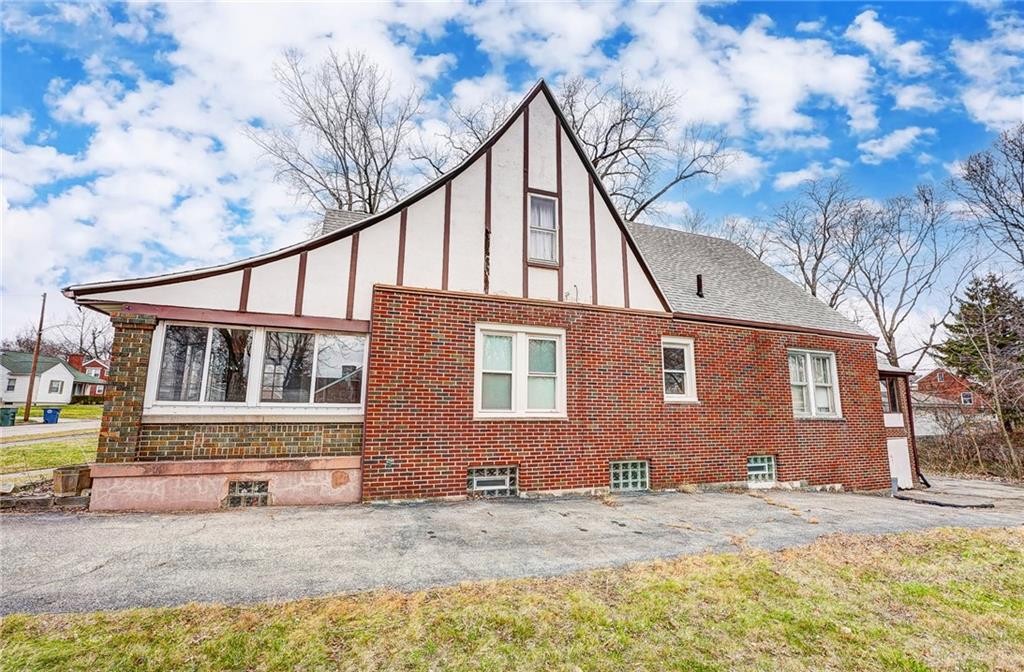 1436 Ruskin Road Dayton, OH 45406 - Photo 2 of 29 This charming home features a distinctive architectural style with brick and white siding, perfect for suburban living.