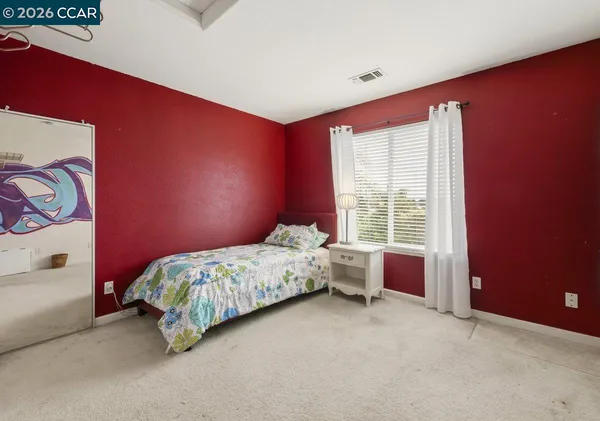 a bed sitting in a bedroom next to a window
